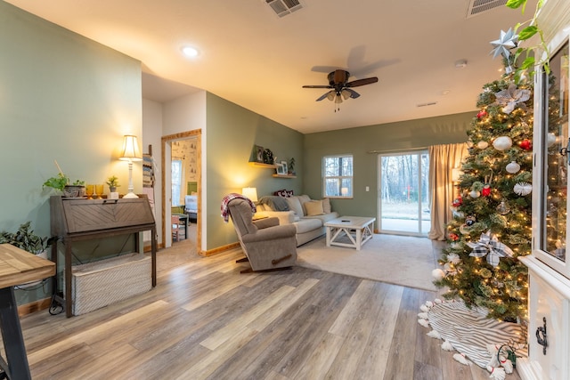 living room with visible vents, baseboards, a ceiling fan, and wood finished floors