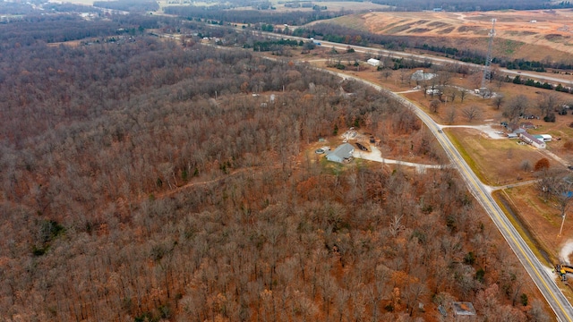 drone / aerial view featuring a view of trees and a rural view