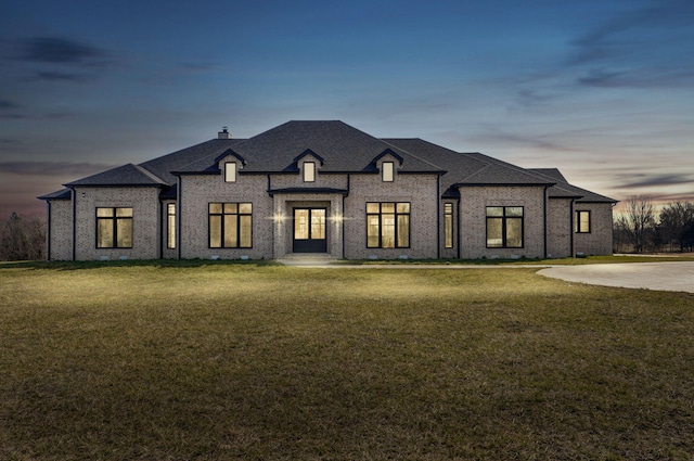 8950 Eagle Prairie Rd, Fair Grove, MO 65648 - french country style house featuring brick siding, a chimney, a front lawn, and a shingled roof