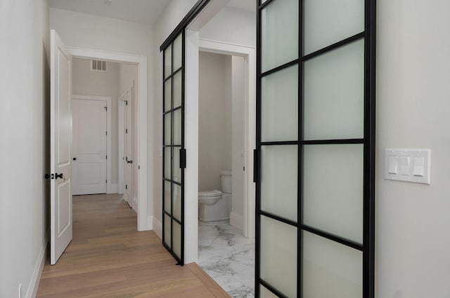 hallway with visible vents, marble finish floor, and french doors