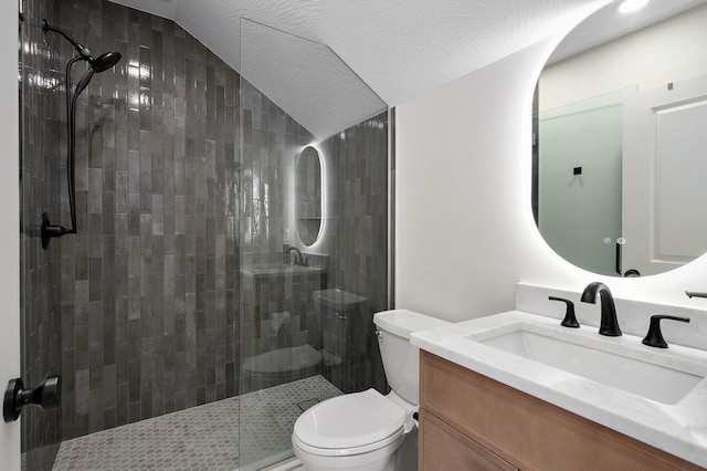 full bathroom featuring toilet, vanity, and a tile shower