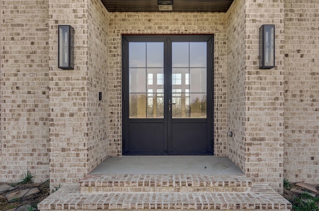 entrance to property featuring french doors and brick siding