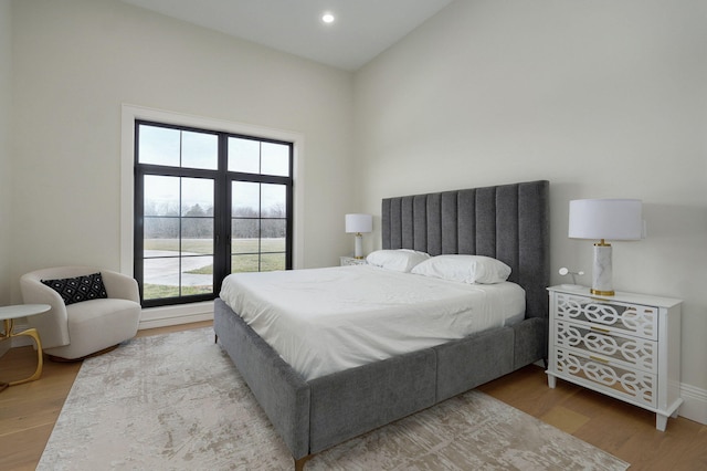 bedroom featuring recessed lighting, baseboards, lofted ceiling, and wood finished floors