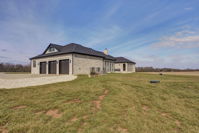 rear view of property featuring concrete driveway, a lawn, and brick siding