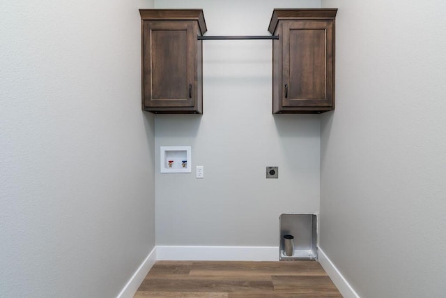 washroom featuring baseboards, hookup for a washing machine, cabinet space, electric dryer hookup, and dark wood-style flooring