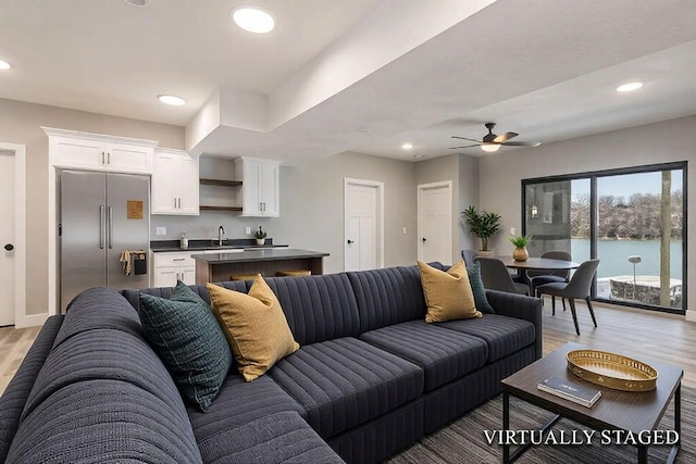 living area with recessed lighting, light wood-style floors, and ceiling fan