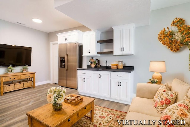 living area featuring visible vents, baseboards, and light wood-style floors