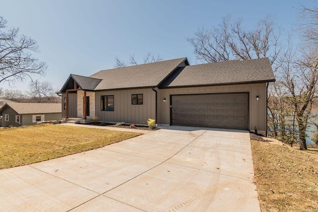 view of front of property featuring a front yard, driveway, roof with shingles, an attached garage, and board and batten siding