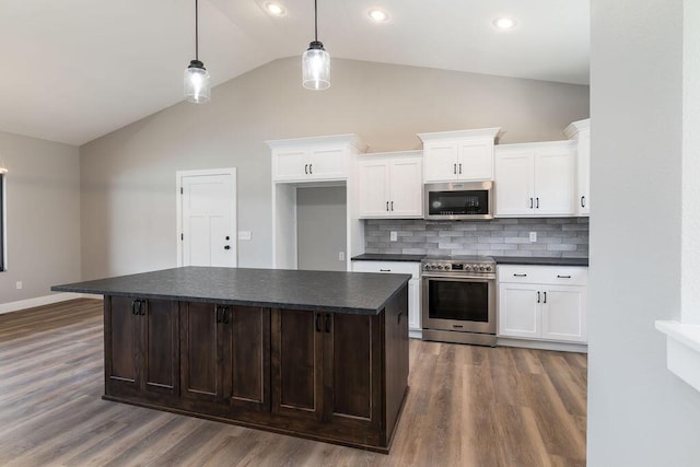 kitchen featuring dark countertops, dark wood-style floors, a kitchen island, and stainless steel appliances