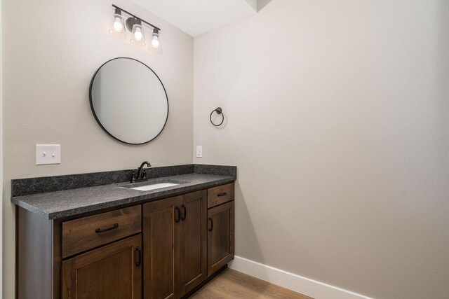 bathroom featuring baseboards, wood finished floors, and vanity