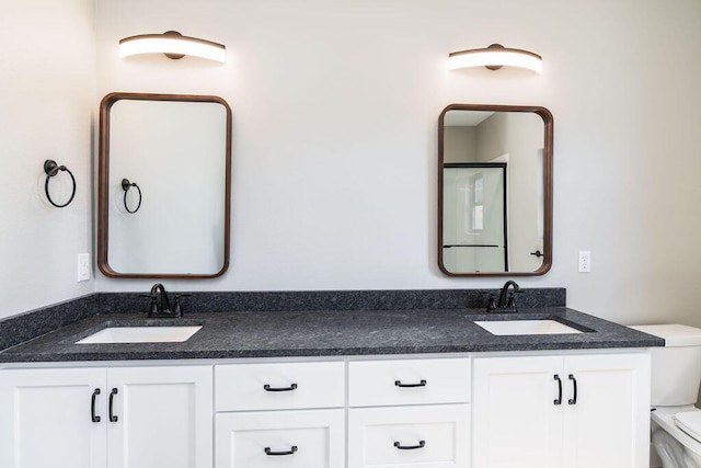 full bathroom with a sink, toilet, and double vanity