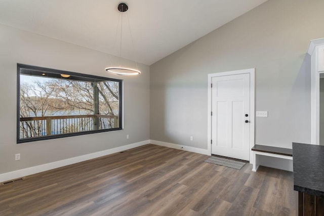 unfurnished dining area featuring visible vents, baseboards, dark wood-style flooring, and vaulted ceiling