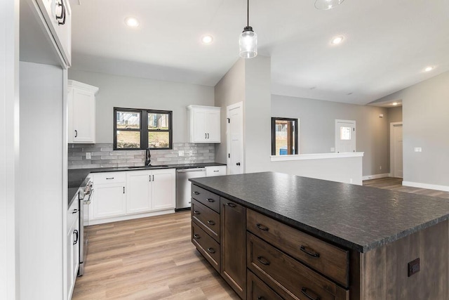 kitchen featuring a sink, dark countertops, appliances with stainless steel finishes, and light wood finished floors