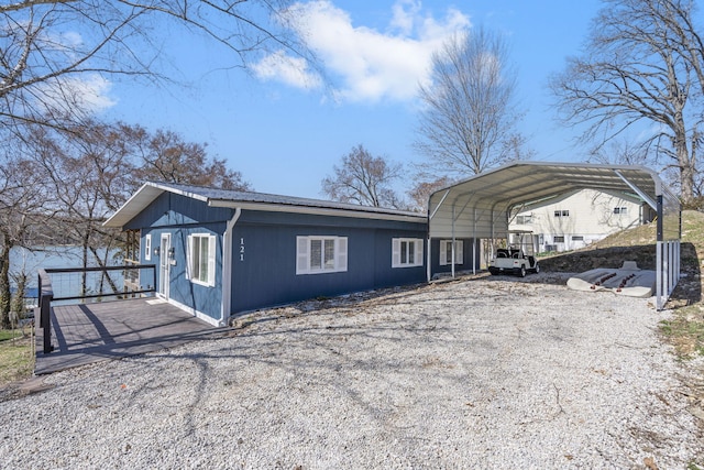 exterior space featuring metal roof, a detached carport, and driveway