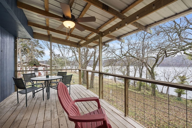 wooden terrace with outdoor dining space and a water view