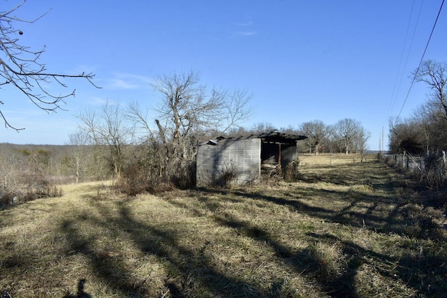 view of yard with an outdoor structure and a rural view