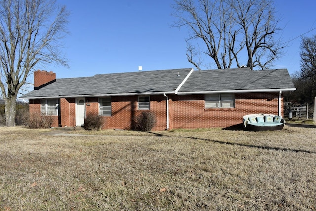 view of side of home featuring a lawn, brick siding, and a chimney