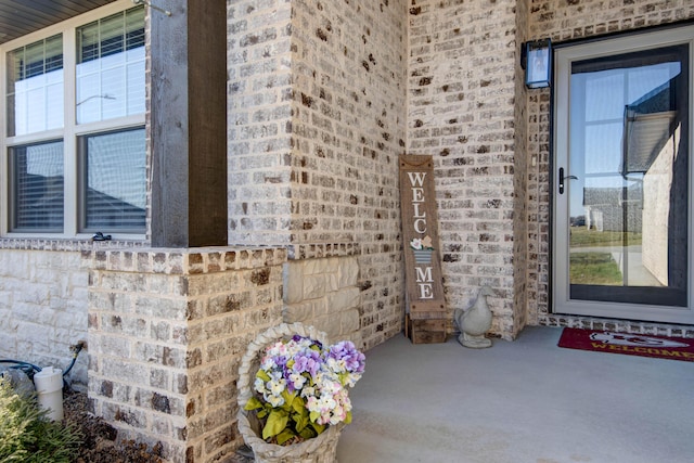 entrance to property featuring brick siding