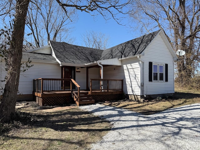 view of front of home with a shingled roof and a deck