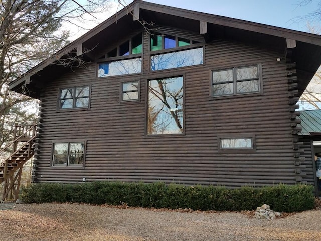 view of side of property with log siding and stairs