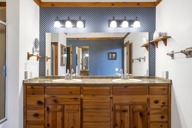 full bath featuring a shower with door, double vanity, and a sink