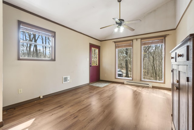 spare room featuring lofted ceiling, ornamental molding, wood finished floors, baseboards, and baseboard heating