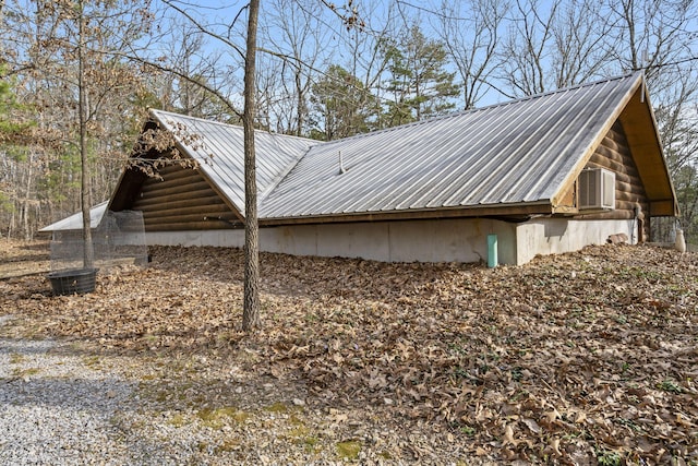 view of property exterior with log exterior and metal roof