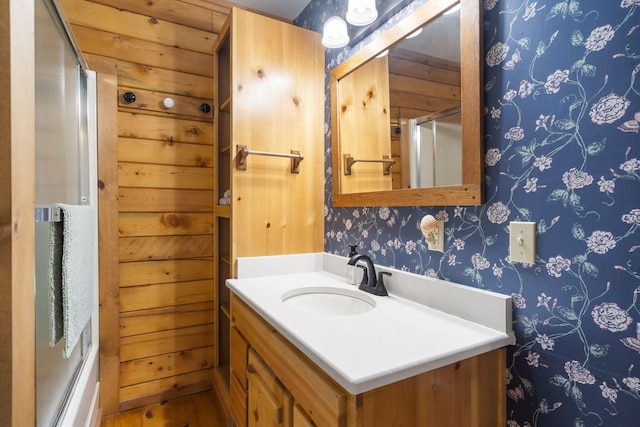 bathroom with an enclosed shower, wallpapered walls, and vanity