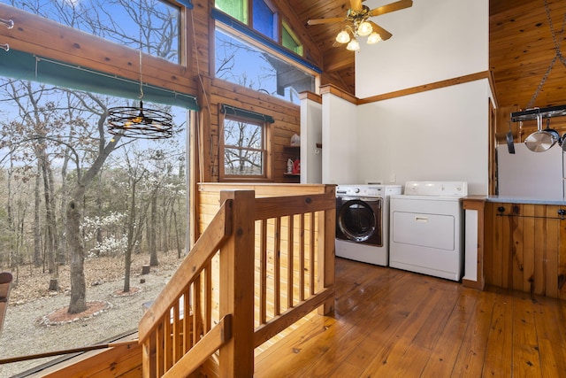 laundry room featuring laundry area, separate washer and dryer, wooden ceiling, a towering ceiling, and wood-type flooring