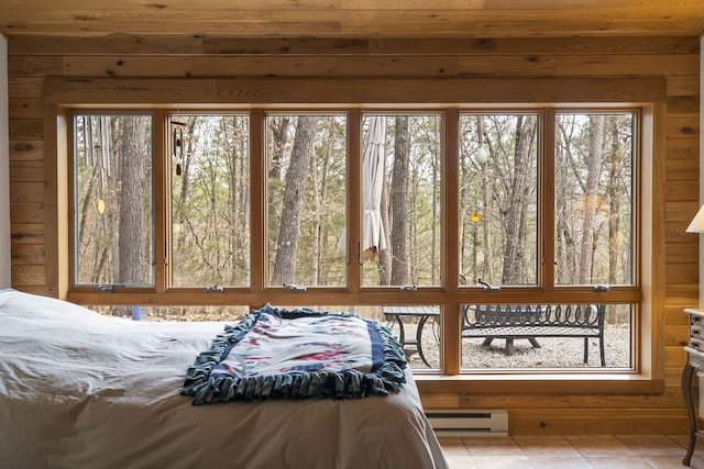 bedroom with light tile patterned flooring, baseboard heating, and wooden walls