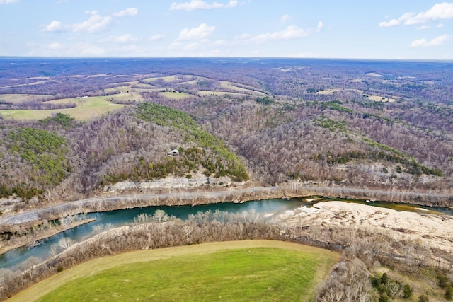 birds eye view of property featuring a forest view and a water view