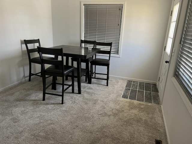 carpeted dining area with baseboards