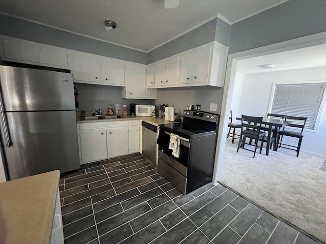 kitchen featuring a sink, stainless steel appliances, white cabinets, and dark carpet