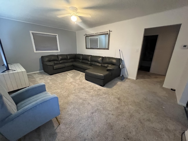 living room with baseboards, a ceiling fan, and carpet floors