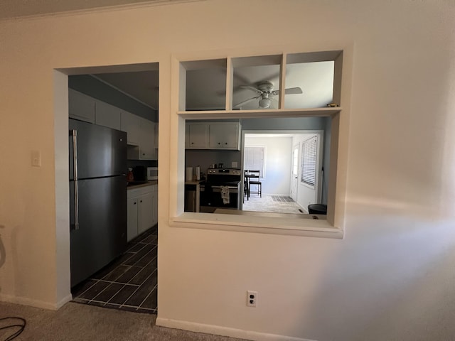 kitchen with dark colored carpet, appliances with stainless steel finishes, and ceiling fan