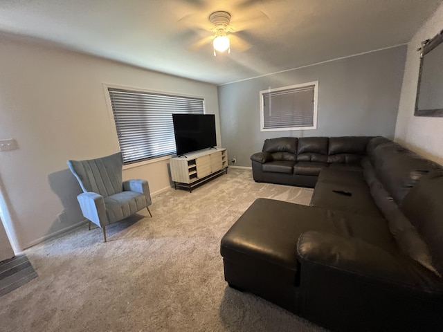 living area with baseboards, ceiling fan, and carpet flooring