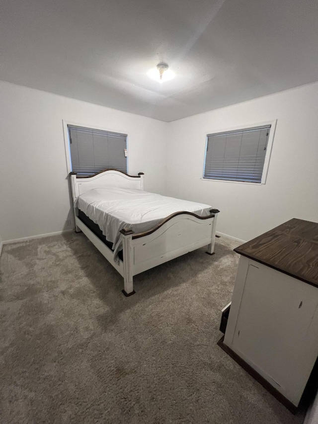 bedroom featuring baseboards and carpet