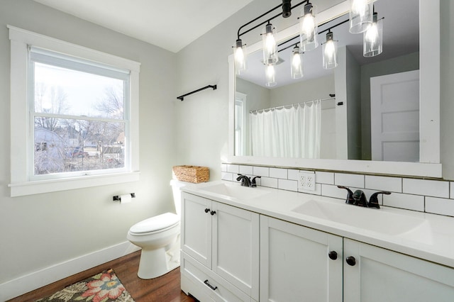 bathroom with decorative backsplash, wood finished floors, and a sink