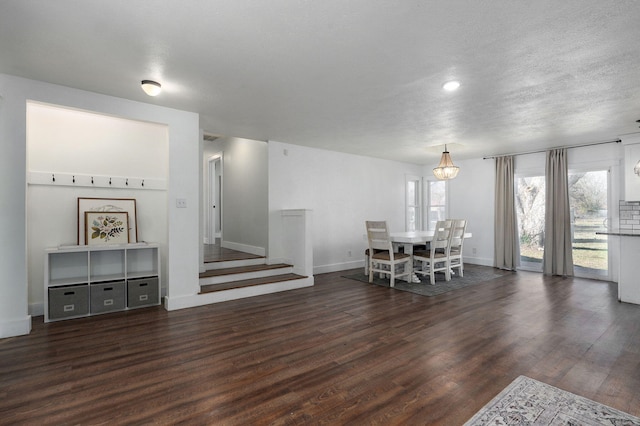 dining space with stairs, wood finished floors, baseboards, and a textured ceiling