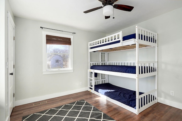 unfurnished bedroom featuring visible vents, a ceiling fan, baseboards, and wood finished floors