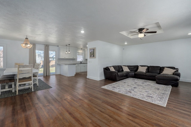 living room with dark wood-type flooring, recessed lighting, a ceiling fan, and baseboards