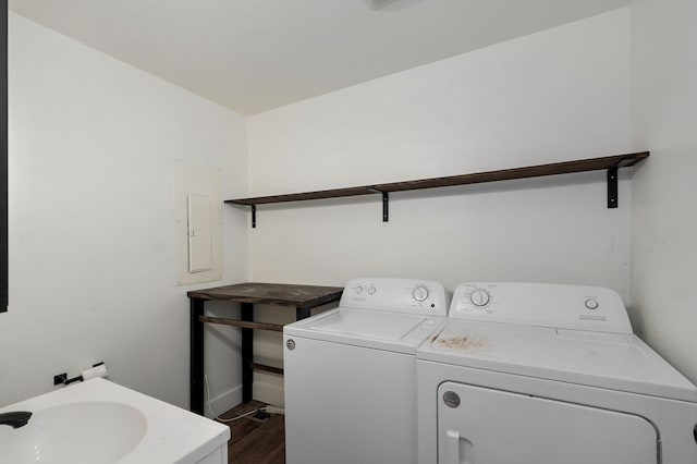 clothes washing area with a sink, laundry area, dark wood-style flooring, and washing machine and clothes dryer