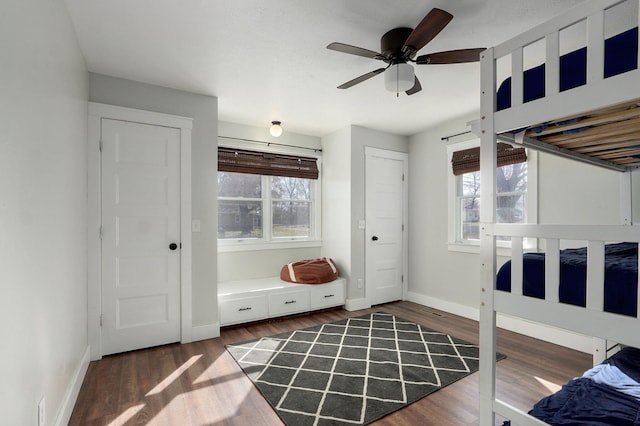 bedroom with ceiling fan, baseboards, and wood finished floors