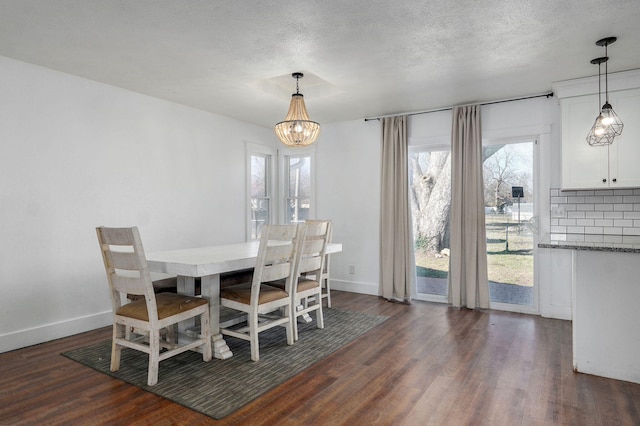 dining room with a textured ceiling, dark wood-type flooring, and baseboards