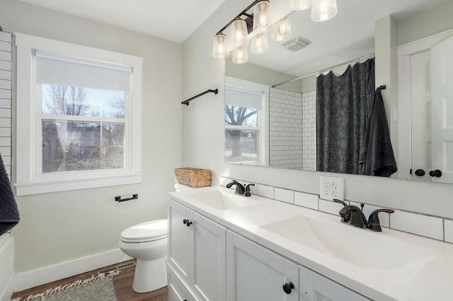 full bath featuring a sink, visible vents, toilet, and wood finished floors