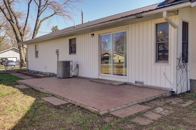 back of property with a patio, central air condition unit, fence, and metal roof