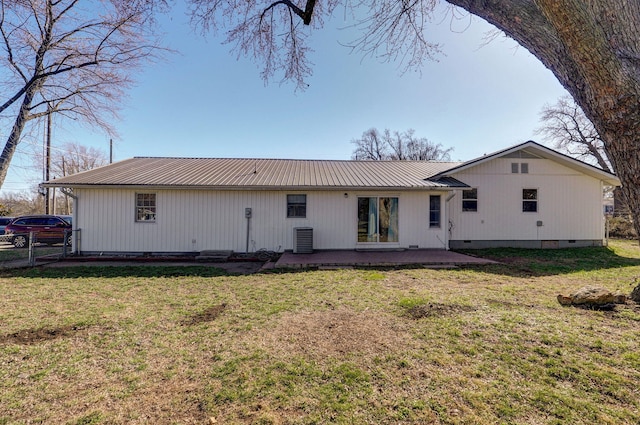 rear view of property featuring a lawn, fence, metal roof, crawl space, and a patio area