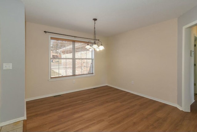 175 Mesquite Dr, Branson, MO 65616 - empty room with visible vents, wood finished floors, baseboards, and a chandelier