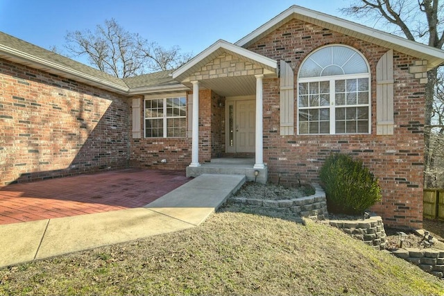 view of exterior entry featuring brick siding