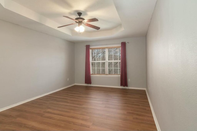 175 Mesquite Dr, Branson, MO 65616 - unfurnished room featuring ceiling fan, baseboards, a tray ceiling, and wood finished floors